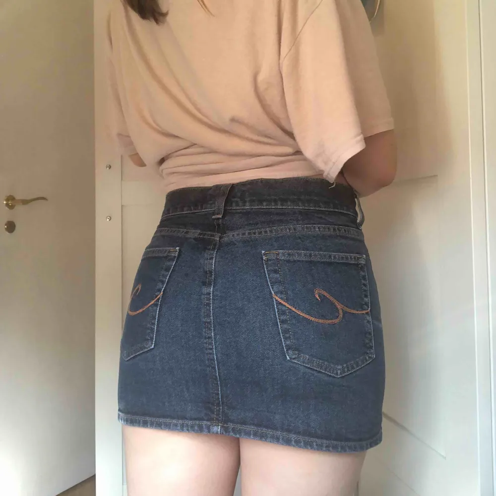 Kort, kort och tajt y2k jeans kjol med broderad design på bakfickorna. . Kjolar.