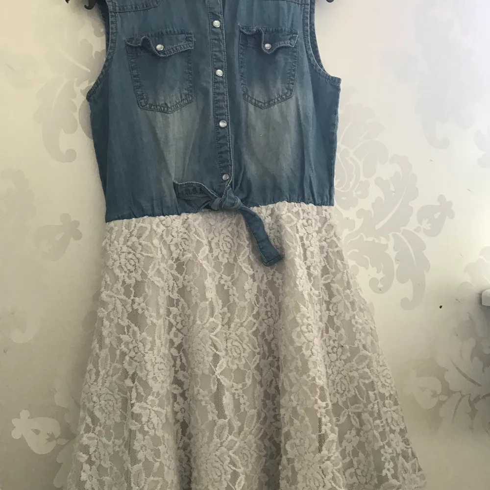 En klänning med en skjort överdel och en blommig kjol ifrån kids i storlek 158. Kjolen har tre lager så den är INTE alls genomskinlig. Klänningar.