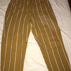 Randiga gul/orangea kostymliknande byxor - Säljer dessa Randiga gul/orangea kostymliknande byxor då de inte passade mig. Kan mötas, vid frakt står köparen för kostnaden.