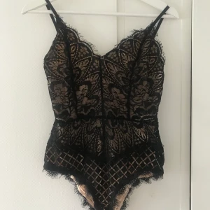 Spetsbody - En snygg body i svart/Nude spets. Inköpt från boohoo för 1 år sen, tror det är storlek M, men den är liten i storleken så den är mer som en XS/S i passformen. Använd 2 gånger 