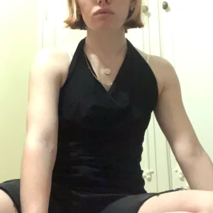 Svart linne - Svart linne som har mer tyg vid bröstkorgen för att få en mer shapeing form. Den går runt halsen och den övre delen av ryggen är öppen. Den är en M.