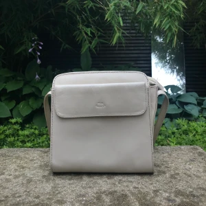 Handväska - Säljer min fina benvita handväska, den är ganska liten ca 20x20cm. Jättemånga fack så hur smidig som helst! Justerbart smalt axelband. Frakt på 55kr tillkommer