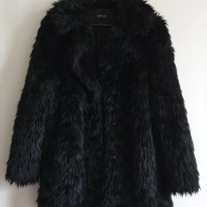 Topshop Urban Shaggy Faux Fur Coat - Fuskpälsjacka från Topshop i storlek 40/UK 12. Inköpt för ca 5 år sedan, använd men har mest hängt i garderoben de senaste åren. Den är fodrad och stängs med tryckknappar. Nypris 999 kr. Katt har funnits i hemmet 🐱 Pris kan diskuteras, PM för frakt!