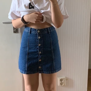 Blå jeanskjol  - Jättesöt blå jeanskjol från H&M✨ knappt använd så i fint skick. 39cm lång. 72cm i midjan. Jag är cirka 158cm lång. Knapparna går att knäppa upp hela vägen ner🌸 Storlek 34. Frakt ingår i priset. Skriv om du har några frågor💞