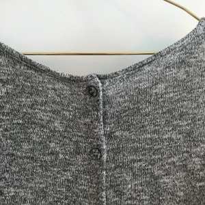 Grå stickad tröja med knappar bak - Storlek XS, men passar även S. Knappar bak. Frakten är inräknad i priset 🤍