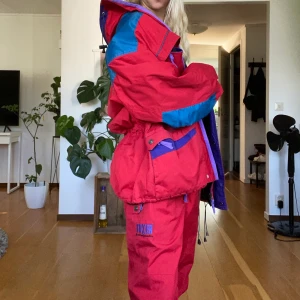 Tuxer vintage skidställ  - Säljer mina föräldrars super sköna retro skidställ från Tuxer sport and Adventure.  Dessa ställ har bara hängt i garderoben i flera år och är väldigt välbevarade och hela med tanke på hur gamla dem är.   FÄRG: Röd, blå, lila Byxorna är med knäpphängslen och två fickor med dragkedja och justerbar resor i midjan. Storlek L. Jackan har fyra fickor, två midjefickor med dragkedja och två bröstfickor med dragkedja samt en bröstficka på insidan. Justerbar resor i kragen, midjan och nedtill. Kragen är fodrad och har Invikbar luva. Storlek L. Köparn står för frakten.