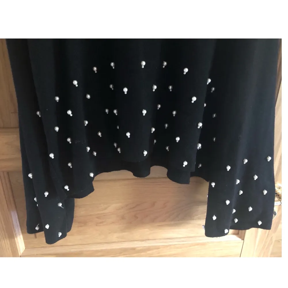 En stickad croppad svart tröja med ballong ärm och vita pärlor på. Finns att hämta i Lund eller skickas, köparen står för frakt.. Tröjor & Koftor.