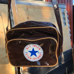 Brun Axelväska 🤎 - (NU SÄNKT PRIS!!) Ascool, brun axelväska med en Converse-liknande logga! Jättefin men kommer inte till användning. Skulle säga att den är i bra skick. Frakt tillkommer eller så möts jag i Stockholm. 😁 priset är diskuterbart!