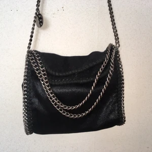  - Svart Stella McCartney inspirerad väska med grå/silvrig kedja. Är knappt använd så den är i nyskick. (Säljer pgr har för många väskor.). Kan mötas upp i Stockholm annars står köparen för frakten.⭐️ 