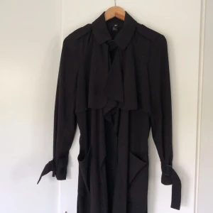  - Favoritkappan från H&M. Svart enkel kappa med fina små detaljer som knäppning vid halsen och spännen vid armarna. Perfekt jacka i vardagen och även för sena utekvällar! 