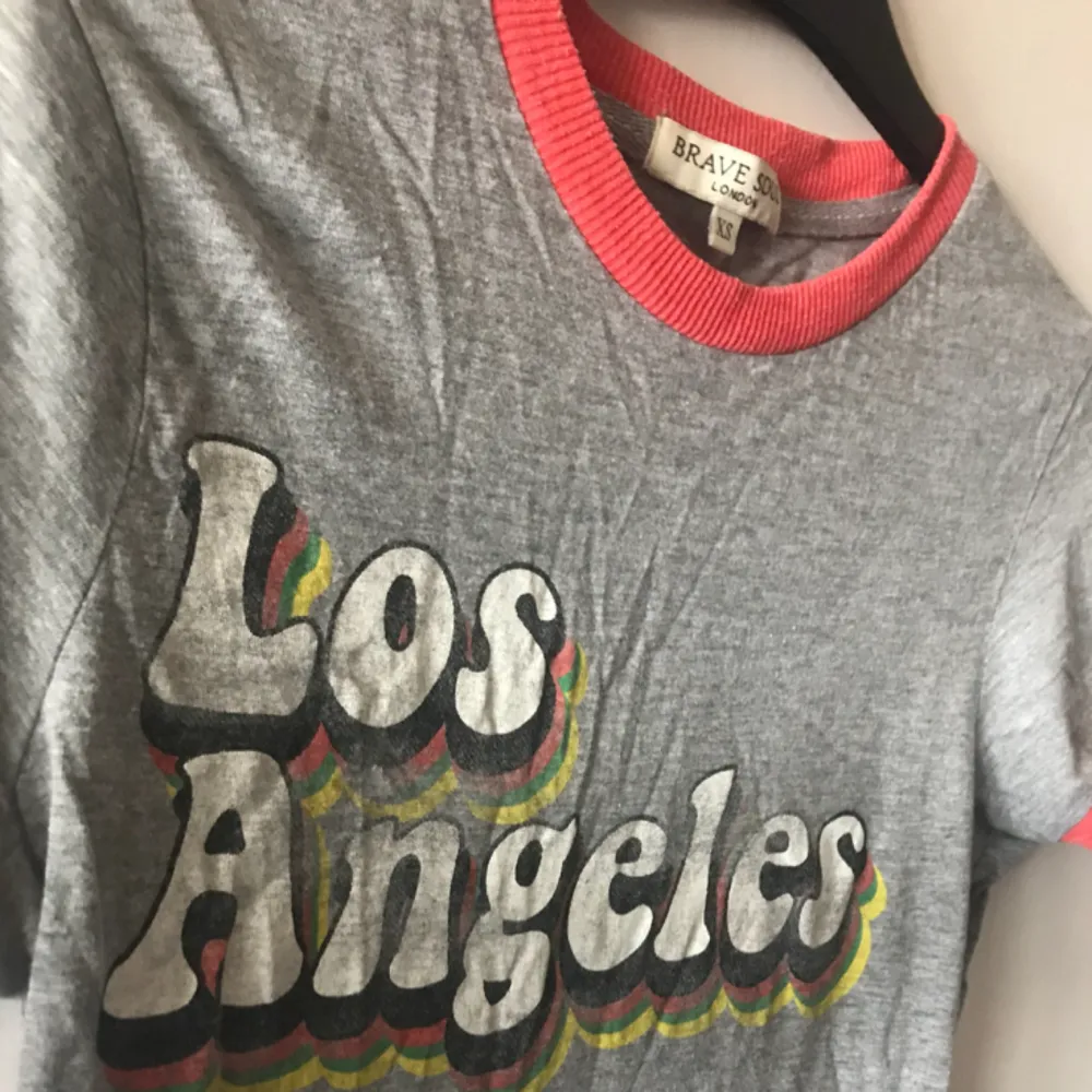 Retro ”Los Angeles” t-shirt i grått med fina färgdetaljer i kragen och på trycket. I XS men sitter bra på mig som oftast är S. Gott skick. Pris kan diskuteras, tar Swish!. T-shirts.