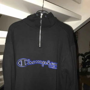  - Svart Champion polo/tjocktroja med blåa inslag i storlek M