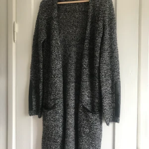 Stickad Cardigan - Fin stickad cardigan i längre modell från HM. Två fickor fram med läder detalj och läderdetaljer på armarna! Är i storlek 170 men skulle säga att den passar S/M också. 🤍🖤