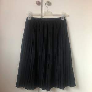 trendig svart pilserad kjol 