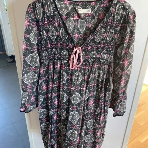 Odd Molly tunika - Tunika med 3/4-ärm som är lätt utsvängd. Längd: 90 cm. Storlek 3 = L. Grå med vit/rosa mönster. Maskintvätt 30 grader. Passar fint till jeans. Om den ska skickas på posten tillkommer fraktkostnad. 