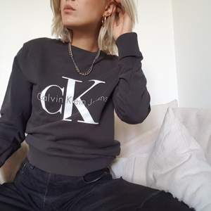 Grå/svart skitsnygg Calvin Klein sweatshirt i unisex xs. Strukturerad och styvt tyg så den sitter snyggt med markerade axlar och rätt åtsittande muddar. Frakt ingår i priset!