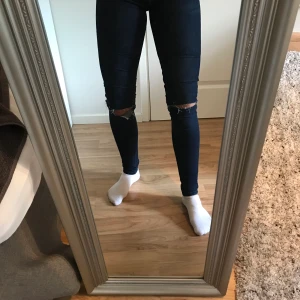 Mörkblå jeans från Hollister - Klippta hål i knäna annars som nya. Köparen står för frakten 