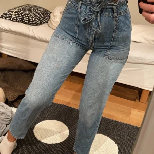 Blåa jeans !!!  - Säljer dessa sjukt snygga jeans från Gina tricot!! Med knytning runt midjan och detaljer framtill ( se bild ) använd en gång så i fint skick. Har dom i en stl 34. Fler bilder vid intresse. 💕💕💕