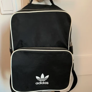 ADIDAS RYGGSÄCK - Super gullig liten ryggsäck från adidas. Säljer för att den inte kommit till användning så många gånger. I perfekt skick. Höjd: 32cm bredd: 23,5cm