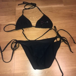 Svart bikini - Fin svart bikini i två delar, med stenar på💕 knyter på sidorna av bikiniunderdelen och knyter baktill och runt på överdelen 💕 säljer pågrund av för liten