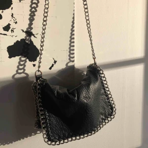  - En svart fakeläder väska från Scorette med snygg kedja. I jättebra skick. Nypris: 450kr