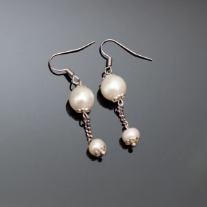  - Fina silverfärgade örhängen med vita pärlor. Krokarna ska vara nickelfria enligt leverantör. Fri frakt vid köp över 100:-.