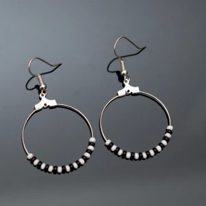  - Fina silverfärgade örhängen med svarta och vita pärlor. Krokarna ska vara nickelfria enligt leverantör.  Fri frakt vid köp över 100:-.