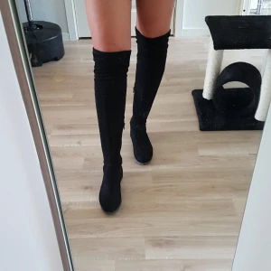  - Svarta over the knee boots i stl. 39. Använda men i fint skick! Dragkedja på insidan samt rosett bak. 