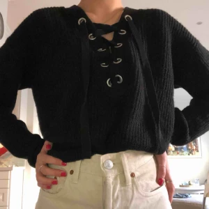  - Svart jätteskön stickad tröja med snörning.  I nyskick