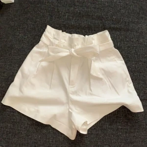 vita shorts i kostymbyxematerial  - Använda några få gånger, köpta på Zara. storlek XS. Riktiga fickor framtill och fake-fickor bak för detaljer. Kan mötas upp i norrköping/söderköping, annars står köpare för fraktkostnad 