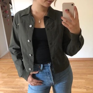 Tunn jacka - Tunn croppad mörkgrön jacka med snake print på nedre inre kanten. I väldigt gott skick!