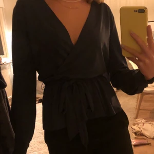 Snygg grön omlottblus  - Skitnsnygg grön omlottblus med band i midjan från hm. Asball grön färg! Ger en väldigt fin form i midjan med bandet. Köpt för 399kr