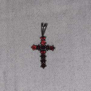Hängsmycke i form av ett kors gjort i silver med fake rubiner (925 stämpel finns baktill). ca 1 cm långt.