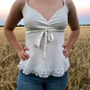 Vit blus/ linne - Fin vit linne blus med rosett i midjan och paljetter nedtill. Samt dragkedja på sidan. 