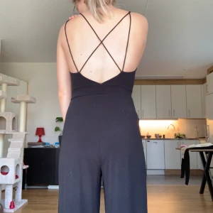 Byxdress med vida ben - Svart byxdress med vida ben. Supersnygg och jätteskön. Dessutom fina detaljer såsom ryggen och framme vid benen. Brukar tex ha en stickad tröja över! Superfint‼️💗🌷