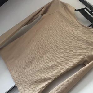 Kamelfärgad tröja med öppen rygg - Kamelfärgad ribbad tröja med ringning på ryggen! Använd 1 gång! Säljs för 80kr frakt ingår 