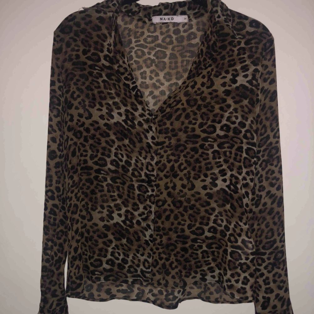 Leopardmönstrad skjorta i tunt tyg. Normal passform med fina volangdetaljer på ärmarna. (Frakt tillkommer). Skjortor.
