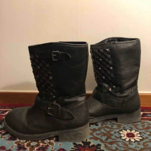  - Svarta boots med nitar i storlek 38. Ganska använda så slitage finns - färg har gått bort från nitar och detaljer. Möts upp i Stockholm och Uppsala, annars tillkommer frakt.