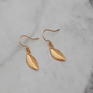 Guldiga löv  - Fina guldfärgade örhängen med löv. Nickelfria.  Obs! Örhängena är inte orangea som på bilden, Photoshop ändrar färgerna för mig 🙃 11:- i frakt, fri frakt vid köp över 100:-.
