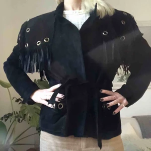  - Svart mockajacka med fransar och gulddetaljer. Band i samma material som jackan, kan knytas i midjan. Funkar som lite oversize om du är xs/s. Jag har vanligtvis 36 eller S. Frakt tillkommer. Kan mötas upp i centrala sthlm.