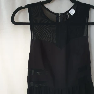  - Långklänning med meshdetaljer både fram och bak på överkroppen. Kortare underklänning som slutar över knät, lätt genomskinligt övre tyg dom går ändå ned till fötterna. Frakt 45kr tillkommer 