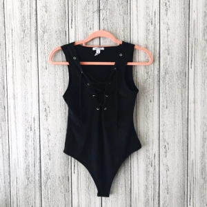  - Body med snörning vid urringningen från Nelly i storleken S. Säljes för 70kr inkl frakt. Aldrig använd, endast prövad. Betalning sker via swish.