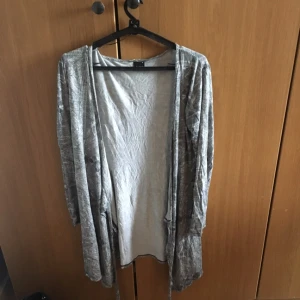  - En lång töjbar blus som har långa band vilket gör att det blir enkelt att vira runt kroppen