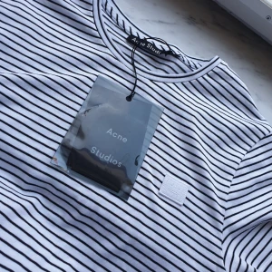  - Acne t-shirt, strl xxs. Svart/vit-randig. Helt ny. Sitter bra på mig som är strl S och 36. 