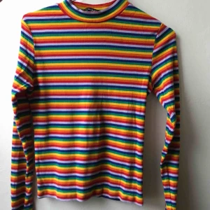  - Säljer denna rengbågsrandiga topp från Monki med halvpolokrage. Inte använd mycket alls. Storleken är S. Fraktar eller möts upp i Stockholm.