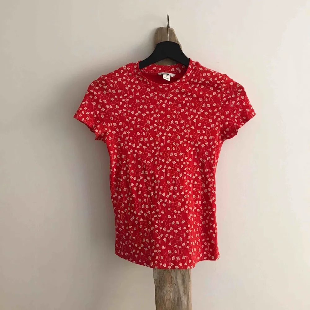 VARA: Röd tunnt ribbad t-shirt med vita blommor från MONKI, ganni inspirerad 🍓  SKICK: inga anmärkningar  MATERIAL: Materiallapp bortklippt. T-shirts.