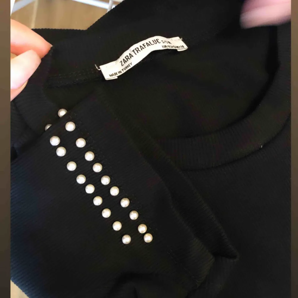 Oanvänd svart t-shirt/blus från Zara, storlek S men känns mer som en XS. Den har jättefina pärlor på ärmarna, superfin detalj🖤 nyskick!   Frakt på 36 kr tillkommer🥰. T-shirts.