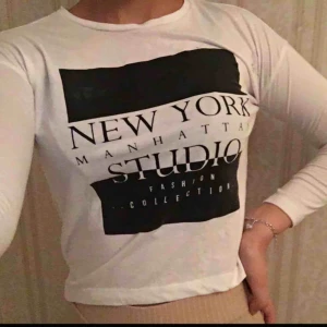  - Vit långärmad tröja med svart tryck. 