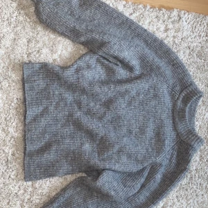Stockaf tröja från Gina Tricot i strl XS - Grå mysig stickad tröja från gina som är köpt 2018. Har inte använt den mycket men är väldig höstig och fin. Ord. Pris 250