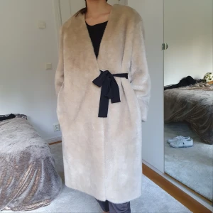Beige fuskpäls från HM i storlek M - Fuskpäls frå  HM i storlek M men passar från XS-L eftersom den kan stylas som oversize eller lite mer tight. Använd ett fåtal gånger och är i bra skick. Pälsen är inte äkta och funkar för veganer, inga skinndetaljer elr liknande.